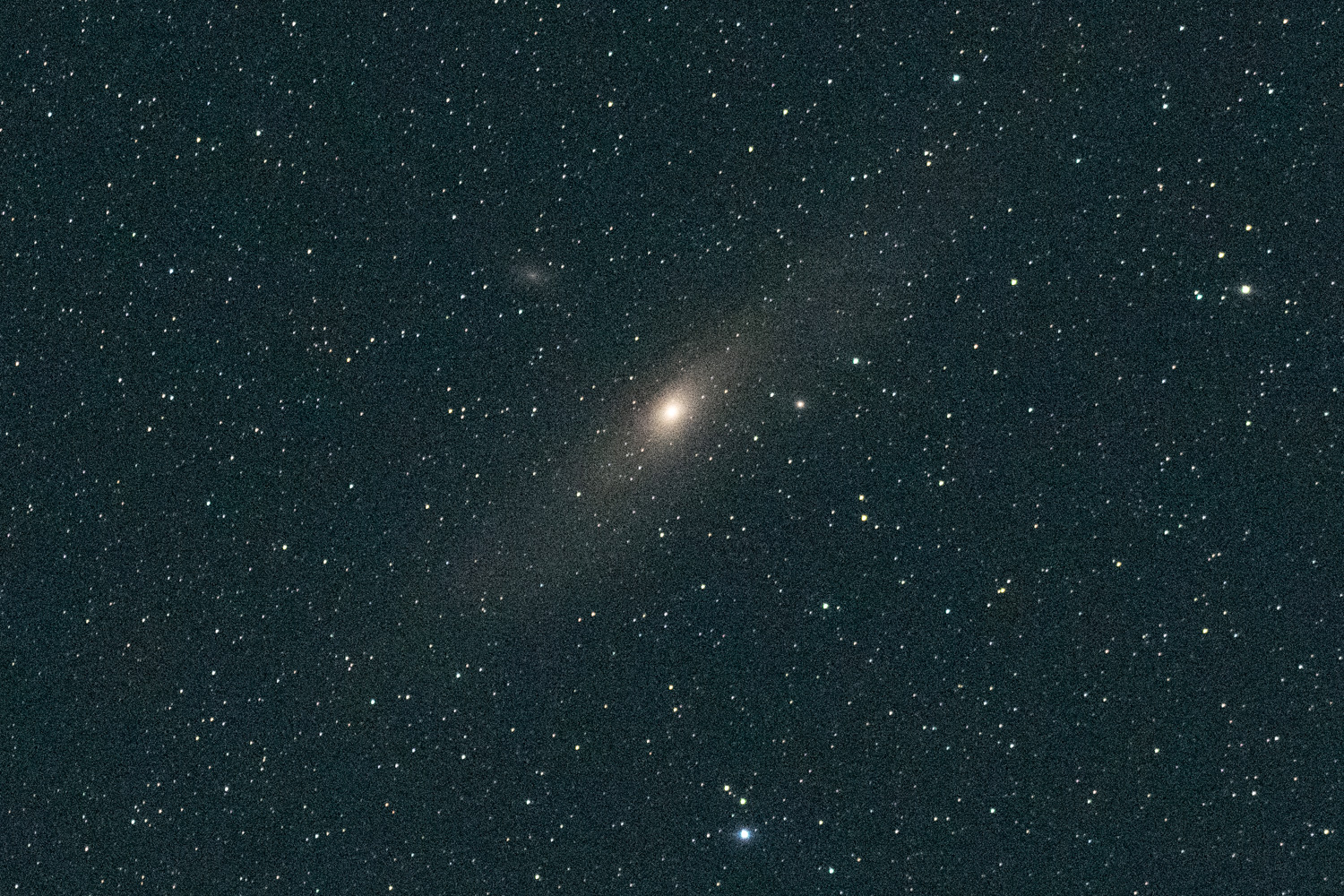 Tracked night-sky exposure with comparatively compact stars around a bright galaxy.