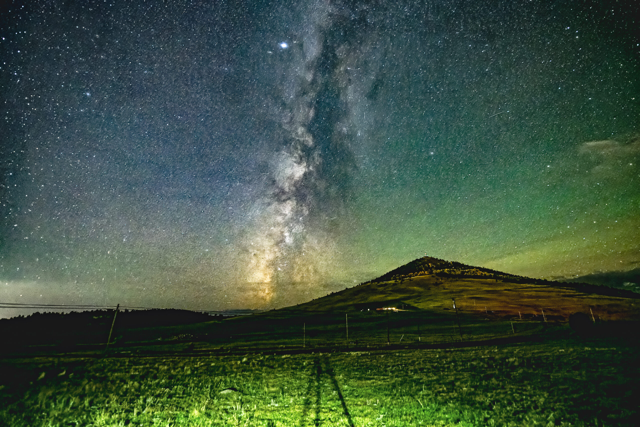 Michael Olson’s finished Milky Way photograph, with brighter sky detail and green foreground above and below the hillside.